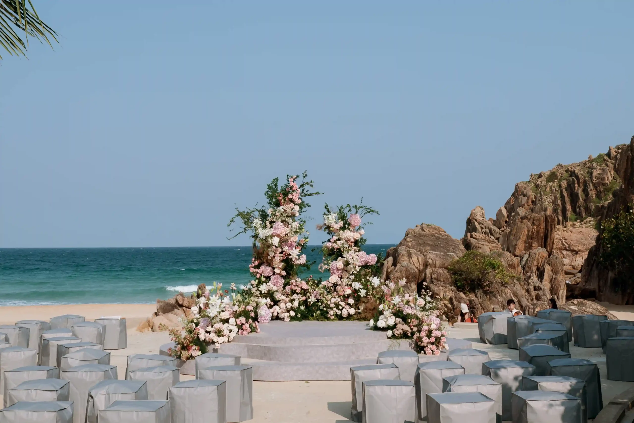 Wedding set up by the rocks on Zannier Bãi San Hô 's white sand beach in Vietnam