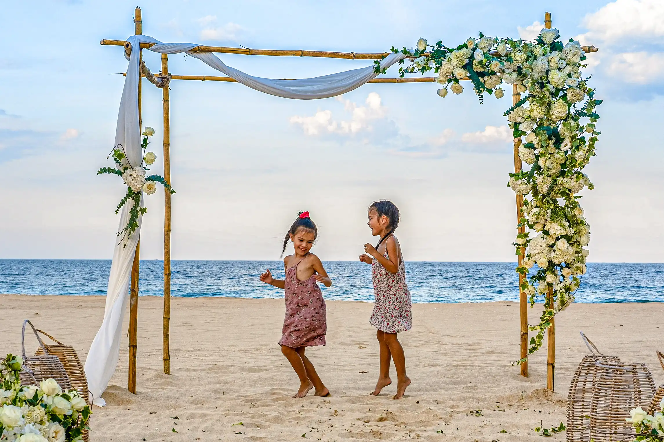 Children playing under a flower arch during a wedding at Zannier Bãi San Hô, Vietnam.